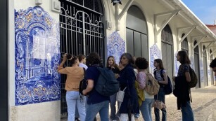uczniowie oglądają niebieską mozaikę na murze