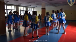 uczniowie tańczą na sali gimnastycznej
