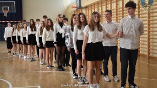 uczniowie tańczą poloneza na sali gimnastycznej
