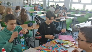 Uczniowie wykonują łańcuch z kolorowego papieru